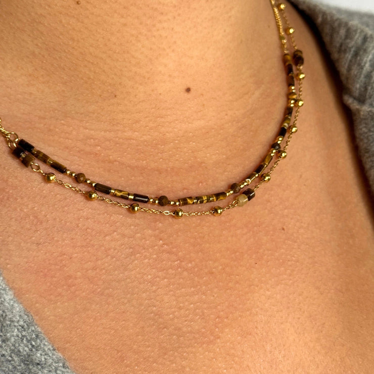 Your new favorite layered moment. The Cocoa Layered Bead Choker is a 14-inch double-strand necklace featuring small long brown beads on one strand and tiny bead details with brown gemstones on the second. A warm, textured, earthy piece crafted in 18k gold-filled materials — hypoallergenic, tarnish-free, and perfect for stacking this season.