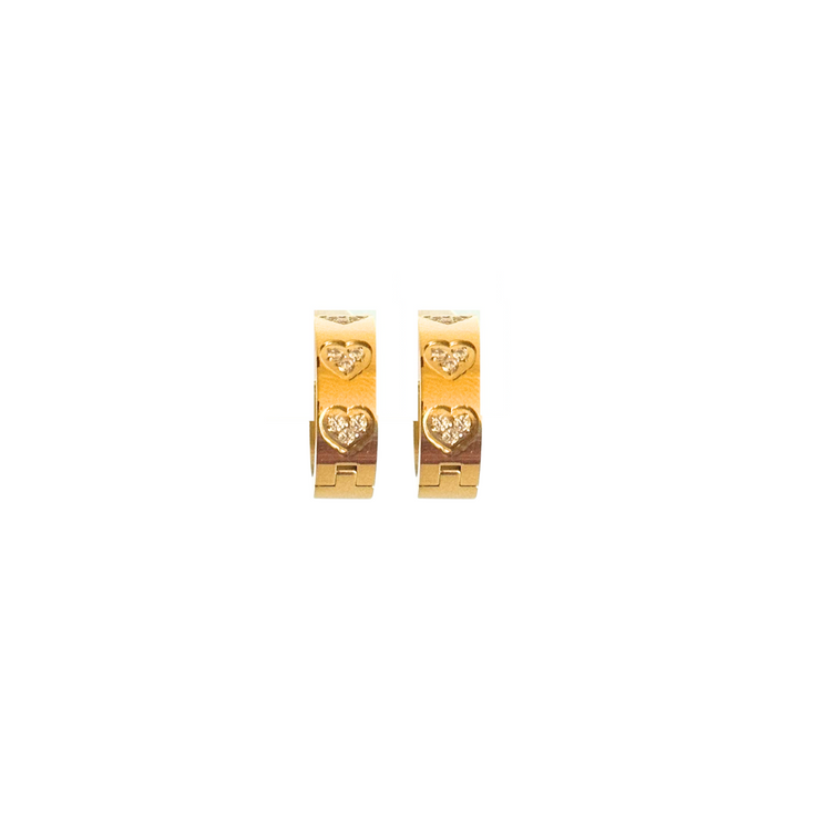 Gold heart-shaped earrings on a white background.These hypoallergenic earrings are a bold yet feminine choice, perfect for day-to-night transitions. Pair them with your favorite chain or wear them solo – they shine either way.
Thick gold hoop earrings with embedded heart-shaped CZ stones, bold romantic jewelry