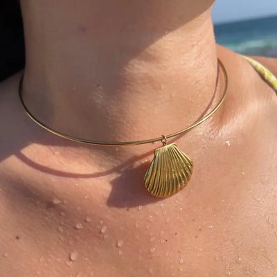 18k gold-filled wire choker necklace with a clam shell charm, styled at the base of the neck.