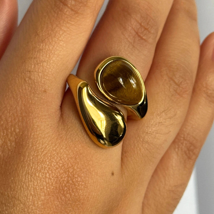 A stunning yin-yang inspired design. The Harmony Dual Gem Adjustable Ring features a beautiful contrast between a white synthetic pearl and a brown tortoise-style resin gemstone. Adjustable from sizes 7–9 and crafted with 18k gold-filled materials, this ring is waterproof, tarnish-free, and the perfect blend of balance and beauty.