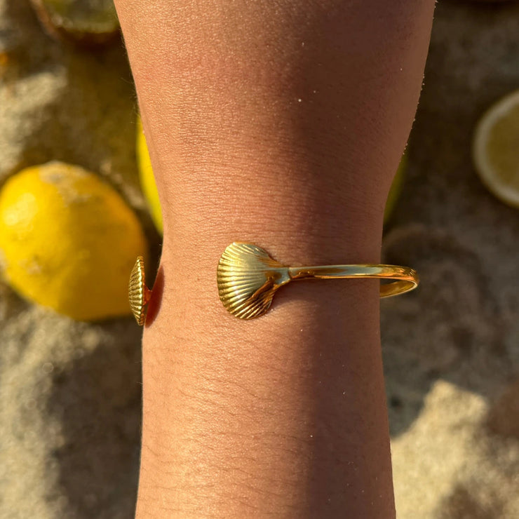 Beach-inspired cuff with seashell ends.Adjustable to fit most wrists. Crafted from waterproof, tarnish-free, 18k gold-plated material — perfect for daily wear.