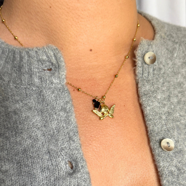 16-inch 18k gold-filled ball chain necklace with angel charm and two small black gemstone charms, hypoallergenic and tarnish-free.