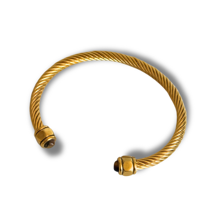 Gold cable bracelet on a white background. Gold-filled twisted open cuff bracelet with gemstone ends in teal, brown, and green on a white background; tarnish-free.”