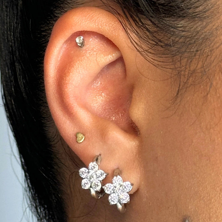 Romantic with a hint of edge. The Celeste Hoop is a dainty medium-sized hoop adorned with flower-shaped details — choose from gold with black CZs or silver with clear CZs. Designed to flow with your every day (and night).