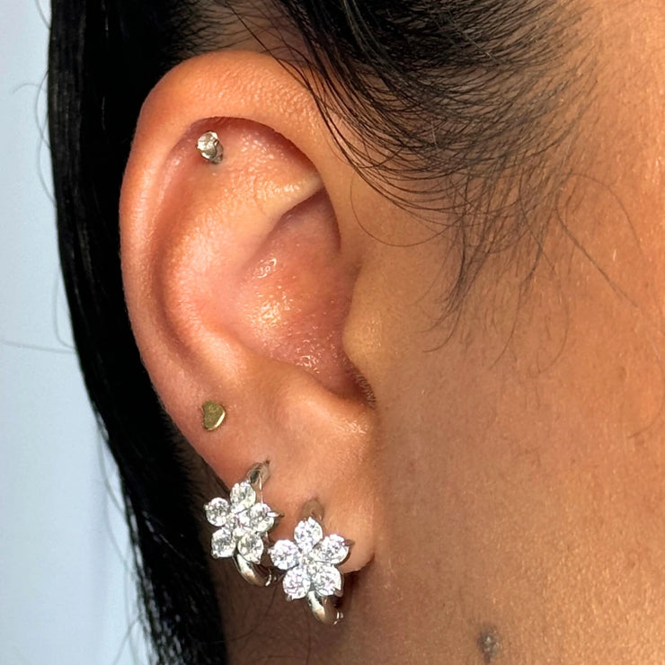 Romantic with a hint of edge. The Celeste Hoop is a dainty medium-sized hoop adorned with flower-shaped details — choose from gold with black CZs or silver with clear CZs. Designed to flow with your every day (and night).