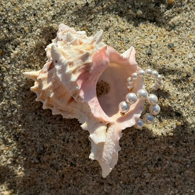 Two gold pearl cuffs, one with small pearls and one with larger pearls, displayed together for a summer-ready ear stack.