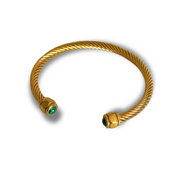 Gold bracelet with green gemstones on a white background. Close-up of open cuff showing twisted band and three gemstone caps—teal, brown, green—set in gold-filled finish.