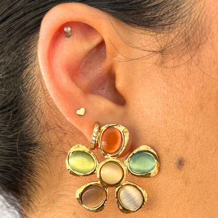 A statement flower bursting with market-day color. Petals shimmer with orange, green, blue, brown, cream, and beige stones—balanced by a warm gold setting. Bold yet wearable for every autumn outfit.