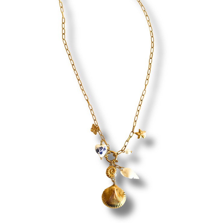 Gold necklace with shell pendant on a white background. paperclip charm necklace, dangle necklace with shells, ocean charm necklace, beach jewelry statement pieces. Gold paperclip chain necklace with layered seashell charms, starfish, bee, and vintage heart

Sea-inspired dangle necklace with ocean-themed charms and pearl accents