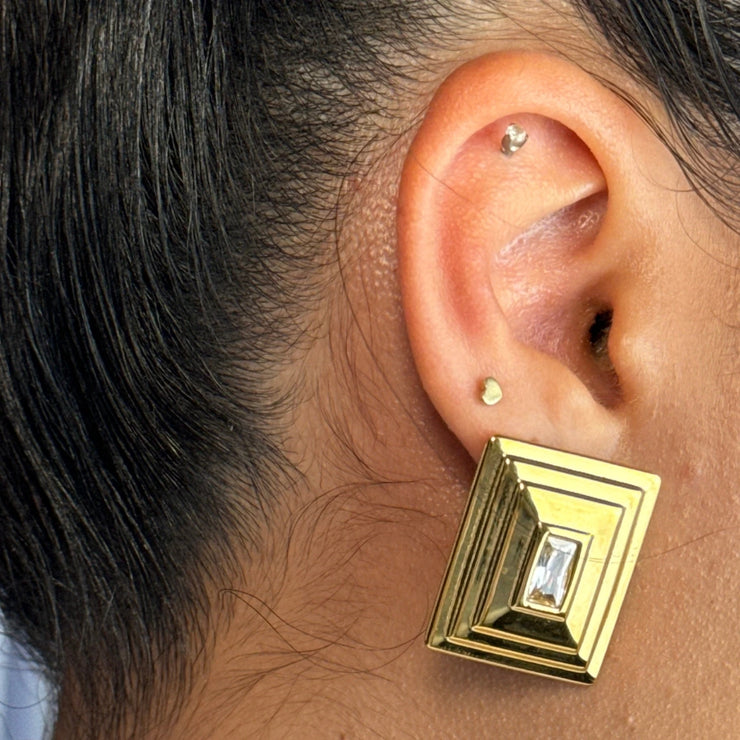 This isn’t your ordinary stud. The Luna Frame features a rectangular CZ at its center, surrounded by a silver and gold outline that adds depth and texture. A layered look without the layering — the perfect statement earring for turning heads effortlessly.