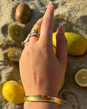 Medium gold cuff with a soft indent in the center, adjustable to fit most wrists.
