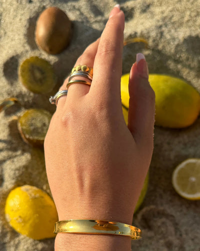 Medium gold cuff with a soft indent in the center, adjustable to fit most wrists.
