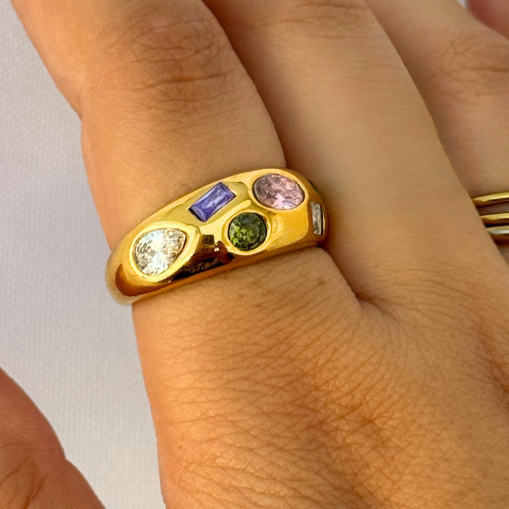Gold ring with colorful gemstones on a person&