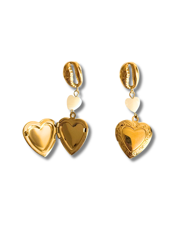 These 18K gold-filled earrings are hypoallergenic and tarnish-free – the perfect summer statement for romantic souls and beach lovers alike.
Gold dangle earring with seashell charm, pearl heart, and heart locket, ocean-inspired