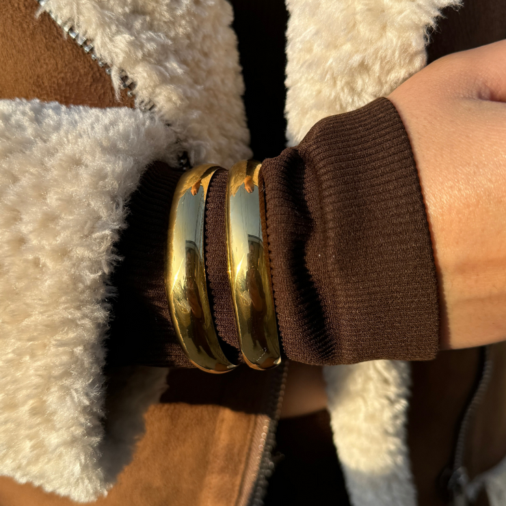 Close-up of adjustable 18k gold-filled double cuff bracelet on wrist, showcasing its shiny, sleek design and trendy layered look tarnish free and water proof.