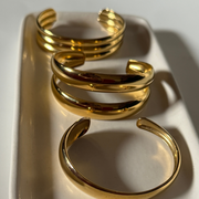 Close-up of adjustable 18k gold-filled double cuff bracelet on wrist, showcasing its shiny, sleek design and trendy layered look tarnish free, water proof, trendy.