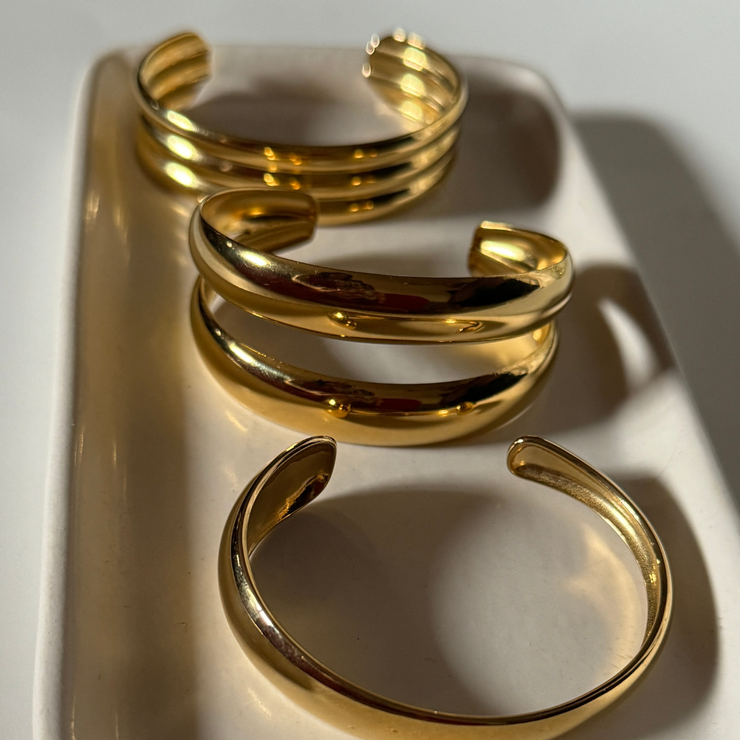 Close-up of adjustable 18k gold-filled double cuff bracelet on wrist, showcasing its shiny, sleek design and trendy layered look tarnish free, water proof, trendy.
