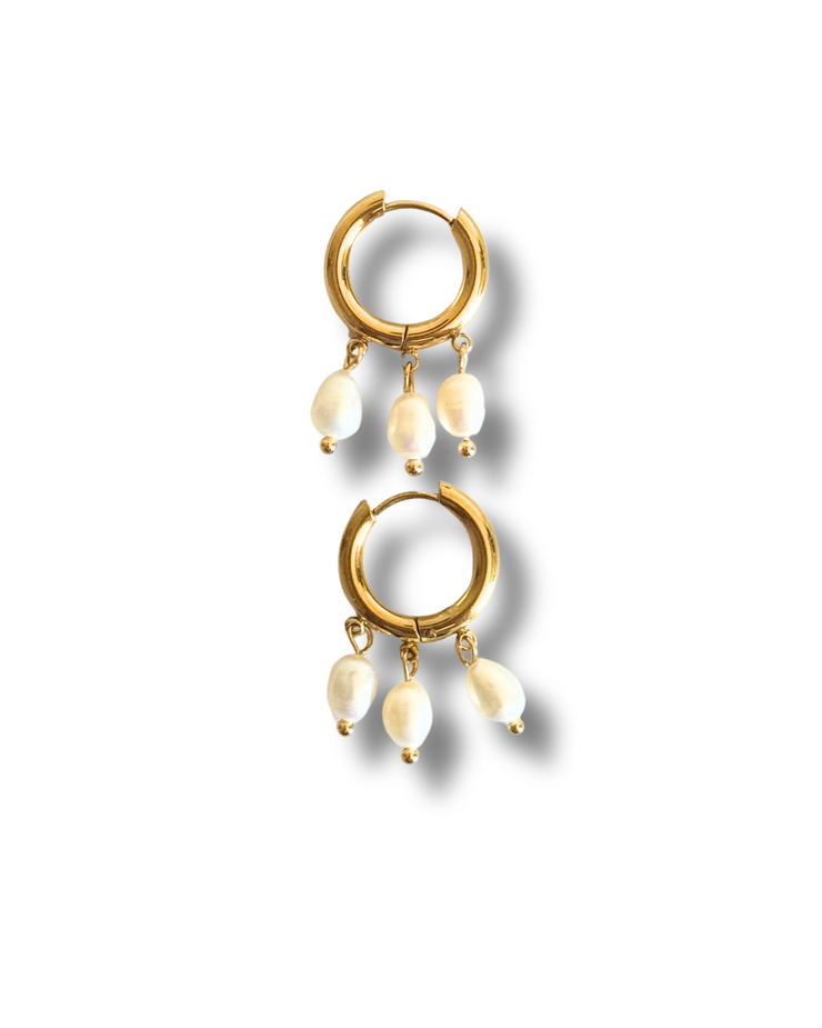 Gold hoop earrings with pearl-like beads on a white background.These 18K gold-filled earrings are hypoallergenic and designed for sensitive skin. Their lightweight elegance makes them ideal for beach days, weddings, or dressing up your everyday look. Gold hoop earring with three dangling freshwater pearls, hypoallergenic summer jewelry