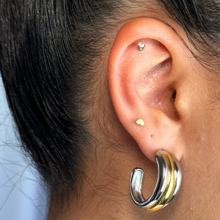 A bold take on balance — the Solstice Hoop plays with duality in the dreamiest way. With a two-tone design, this piece features a radiant gold center hugged by silver ends and fine line details that melt from thick to thin. Lightweight but powerful, it’s your new go-to for statement styling.