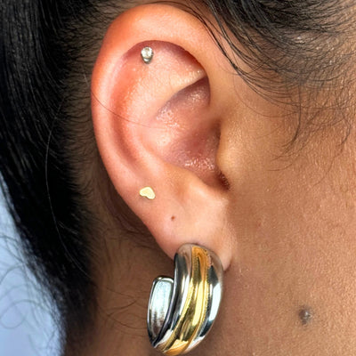 A bold take on balance — the Solstice Hoop plays with duality in the dreamiest way. With a two-tone design, this piece features a radiant gold center hugged by silver ends and fine line details that melt from thick to thin. Lightweight but powerful, it’s your new go-to for statement styling.