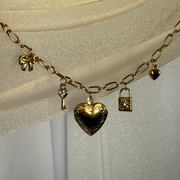 Elegant charm bracelet with a lock and key, bow, and heart locket to keep a treasured photo close. Hypoallergenic, tarnish-free, and a timeless accessory for any jewelry collection.