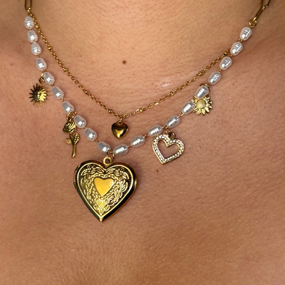  Elegant freshwater pearl locket necklace featuring a bubble heart locket, dainty chain, and pre-selected charms including a sun, rose, heart, and flower. Hypoallergenic, tarnish-free, and waterproof for a timeless, sentimental look.