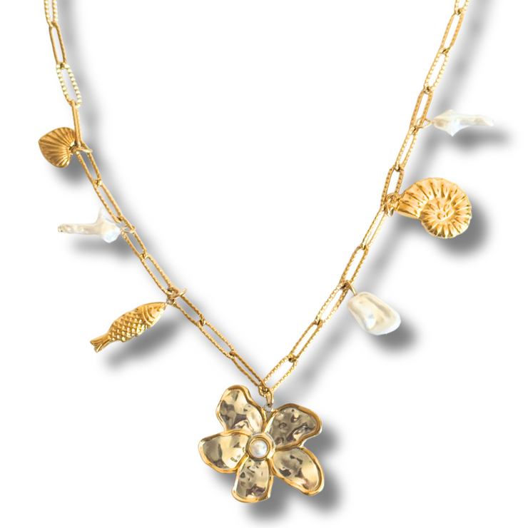 Gold necklace with floral pendant and shell elements on a white background.this layered charm necklace brings beachside beauty to your everyday look. Tarnish-free and hypoallergenic, it’s made for sensitive skin and everyday wear.
mixed metal charm necklace, floral pearl necklace, coastal necklace, seashell charm necklace, beach jewelry
Mixed Metal Flower and Pearl Charm Necklace

Coastal Bloom Gold and Silver Necklace

Mixed metal necklace with floral 