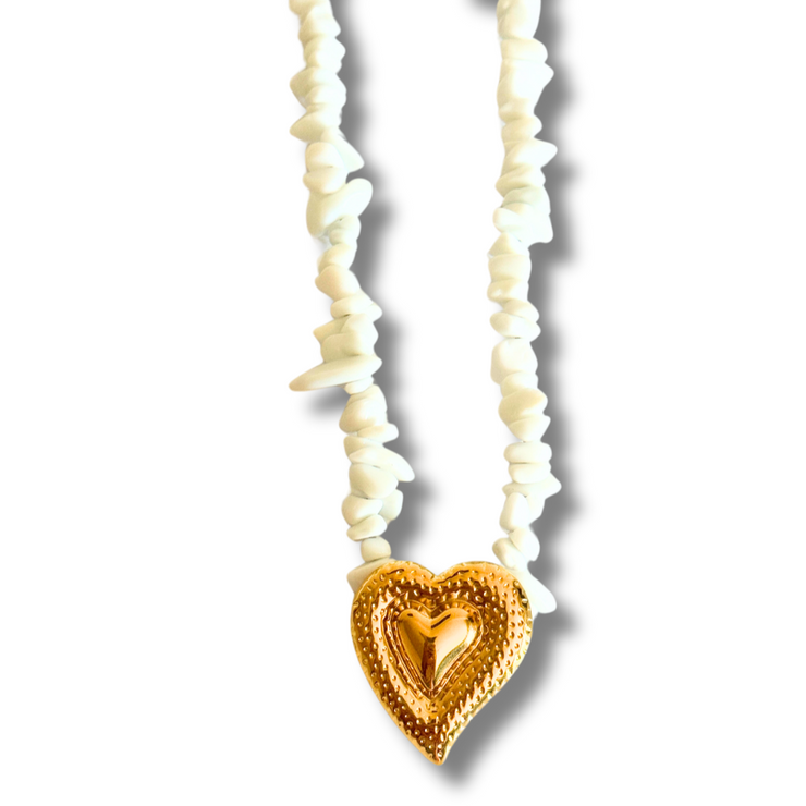 Necklace with white shell beads and a gold heart-shaped pendant on a white background. natural stone heart necklace, beach stone jewelry, white stone necklace, textured heart pendant, romantic summer jewelry
Waves of Love White Stone and Heart Necklace
Natural Beachy Necklace with Textured Heart Pendant
Natural white stone necklace with gold wavy heart charm
Beach-inspired necklace with organic stones and romantic heart centerpiece
